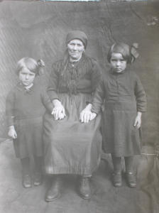 Donna in abito tradizionale con bambine (1930)